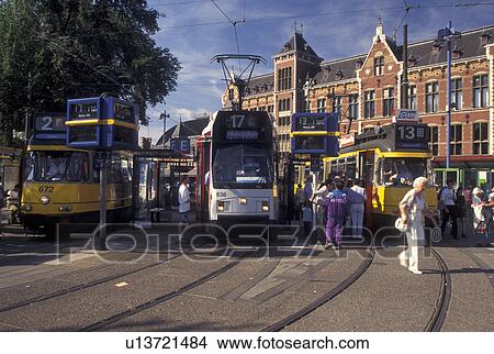 Amsterdam, Holland, Central Station, Netherlands, Noord-Holland, Europe, People boarding trams outside Centraal Station (CS) in the city of Amsterdam. View Large Photo Image Picture - Amsterdam, Holland, Central Station, Netherlands, Noord-Holland, Europe, People boarding trams outside Centraal Station (CS) in the city of Amsterdam.. Fotosearch