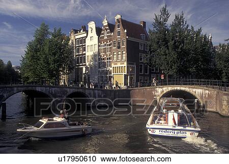 Amsterdam, Holland, Netherlands, Noord-Holland, Europe, Sightseeing tour boat cruises along a canal in Amsterdam. View Large Photo Image Stock Image - Amsterdam, Holland, Netherlands, Noord-Holland, Europe, Sightseeing tour boat cruises along a canal in Amsterdam.. Fotosearch