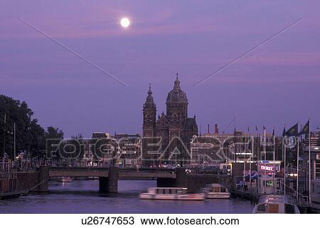 Stock Image -  Amsterdam, Holland, Netherlands, Noord-Holland, Europe, Full moon rising over canal in the evening in Amsterdam.. Fotosearch