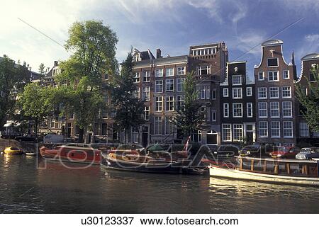 Amsterdam, Holland, Netherlands, Noord-Holland, Europe, Houseboats docked along a canal in Amsterdam. View Large Photo Image Stock Photo - Amsterdam, Holland, Netherlands, Noord-Holland, Europe, Houseboats docked along a canal in Amsterdam.. Fotosearch