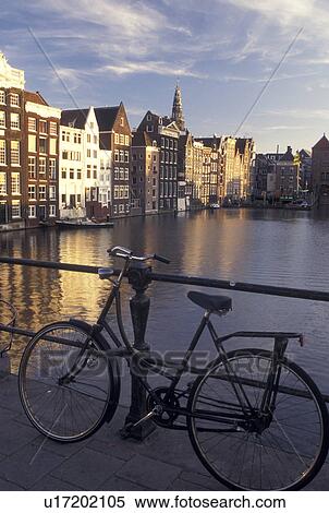Amsterdam, Holland, Netherlands, Noord-Holland, Europe, Bikes lean against railing along a canal in Amsterdam. View Large Photo Image Stock Photography - Amsterdam, Holland, Netherlands, Noord-Holland, Europe, Bikes lean against railing along a canal in Amsterdam.. Fotosearch