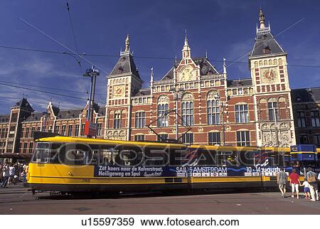 Stock Photo -  Amsterdam, Netherlands, Central Station, Holland, Noord-Holland, Europe, Yellow tram outside Centraal Station (CS) in the city of Amsterdam.. Fotosearch