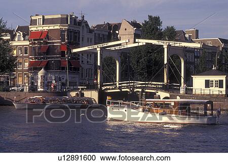 Amsterdam, Netherlands, Holland, Noord-Holland, Europe, Drawbridge on a canal in Amsterdam. View Large Photo Image Stock Image - Amsterdam, Netherlands, Holland, Noord-Holland, Europe, Drawbridge on a canal in Amsterdam.. Fotosearch