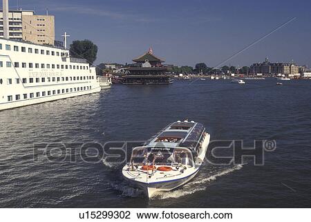 Stock Image -  Amsterdam, Netherlands, Holland, Noord-Holland, Europe, Sightseeing boat cruises along Oosterdok in Amsterdam.. Fotosearch