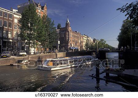 Amsterdam, Netherlands, Holland, Noord-Holland, Europe, Sightseeing tour boat cruises along a canal in Amsterdam. View Large Photo Image Stock Photo - Amsterdam, Netherlands, Holland, Noord-Holland, Europe, Sightseeing tour boat cruises along a canal in Amsterdam.. Fotosearch