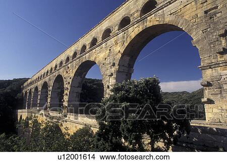Picture -  aqueduct, Pont du Gard, France, Languedoc-Roussillon, Europe, Three-tiered 19 BC Roman Aqueduct, Pont du Gard spans the Gardon River.. Fotosearch