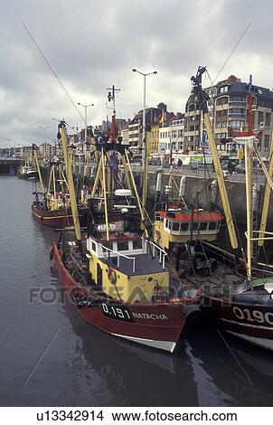 Picture -  Belgium, Oostende, West-Vlaanderen, Europe, North Sea, Fishing boats docked along the harbor in the town of Oostende.. Fotosearch