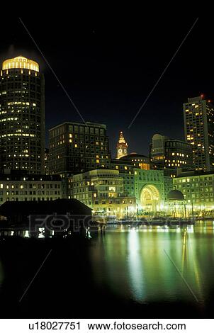 Stock Image -  Boston, skyline, MA, Massachusetts, The lights of the downtown skyline of Boston reflect in the calm waters of the Boston Harbor at night. . Fotosearch