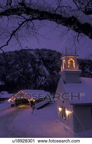 Stock Image -  church, covered bridge, NH, New Hampshire, Stark, Christmas lights decorate the Stark Union Church and covered bridge in the evening in winter.. Fotosearch