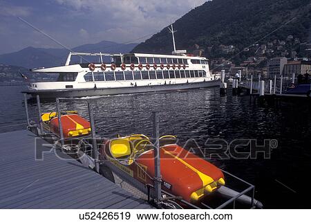 Stock Photo -  Como, Italy, Lombardy, Lombardia, Lake Como, Southern Alps, Excursion boat on the waterfront on Lake Como in the harbor of the village of Como.. Fotosearch