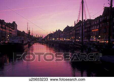 Stock Image -  Denmark, Copenhagen, canal, Scandinavia, Sjaelland, Europe, Boats docked along Nyhavn (New Harbor) in the evening in the scenic city of Copenhagen. Fotosearch