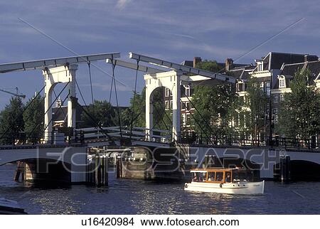 drawbridge, Amsterdam, Holland, Netherlands, Noord-Holland, Europe, Boat cruises under Skinny Drawbridge on a canal in Amsterdam. View Large Photo Image Picture - drawbridge, Amsterdam, Holland, Netherlands, Noord-Holland, Europe, Boat cruises under Skinny Drawbridge on a canal in Amsterdam.. Fotosearch