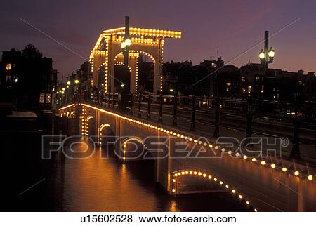 drawbridge, Amsterdam, Holland, Netherlands, Noord-Holland, Europe, Skinny Drawbridge illuminated at night on a canal in Amsterdam. View Large Photo Image Stock Photo - drawbridge, Amsterdam, Holland, Netherlands, Noord-Holland, Europe, Skinny Drawbridge illuminated at night on a canal in Amsterdam.. Fotosearch