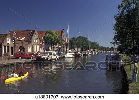 Stock Photo -  Edam, Netherlands, Holland, Noord-Holland, Europe, Kayaking down a canal in the city of Edam.. Fotosearch