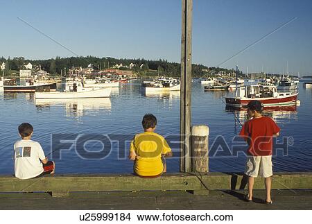 fishing, Bass Harbor, Mount Desert Island, ME, Maine, Boys fishing off the pier with view of lobster fishing boats buoyed in the harbor in the fishing village of Bass Harbor on the Atlantic Ocean. View Large Photo Image Picture - fishing, Bass Harbor, Mount Desert Island, ME, Maine, Boys fishing off the pier with view of lobster fishing boats buoyed in the harbor in the fishing village of Bass Harbor on the Atlantic Ocean.. Fotosearch