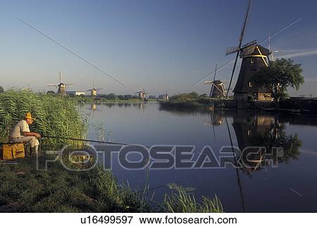 fishing, canal, windmill, Kinderdijk, Holland, Netherlands, Zuid-Holland, Europe, Mills of Kinderdijk, Man fishing along the canal near windmills in Kinderdijk. View Large Photo Image Stock Photo - fishing, canal, windmill, Kinderdijk, Holland, Netherlands, Zuid-Holland, Europe, Mills of Kinderdijk, Man fishing along the canal near windmills in Kinderdijk. . Fotosearch