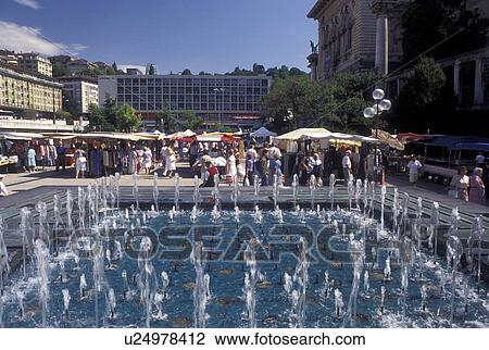 Stock Image -  fountain, Switzerland, Lausanne, Vaud, Market day in Place de la Riponne in the city of Lausanne.. Fotosearch