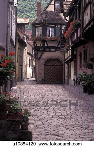 France, Alsace, Kaysersberg, Haut-Rhin, Europe, wine region, Half-timbered buildings decorated with red geraniums along a narrow cobbled street in the picturesque village of Kaysersberg in the wine region of Alsace. View Large Photo Image Stock Image - France, Alsace, Kaysersberg, Haut-Rhin, Europe, wine region, Half-timbered buildings decorated with red geraniums along a narrow cobbled street in the picturesque village of Kaysersberg in the wine region of Alsace.. Fotosearch