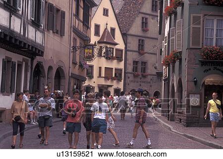 Stock Image -  France, Alsace, Kaysersberg, Haut-Rhin, Europe, wine region, People shopping along the narrow cobblestone pedestrian streets surrounded by half-timbered buildings in the picturesque village of Kaysersberg in the wine region of Alsace.. Fotosearch