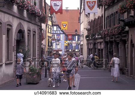 France, Alsace, Ribeauville, Haut-Rhin, Europe, wine region, People walking along the narrow streets surrounded by half-timbered buildings in the picturesque village of Ribeauville in the wine region of Alsace. View Large Photo Image Stock Image - France, Alsace, Ribeauville, Haut-Rhin, Europe, wine region, People walking along the narrow streets surrounded by half-timbered buildings in the picturesque village of Ribeauville in the wine region of Alsace.. Fotosearch