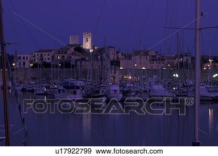 Stock Photo -  France, Antibes, Cote d' Azur, Provence, Alpes-Maritimes, Europe, Boats docked in Port Vauban Harbor on the Mediterranean Sea in the city of Antibes in the evening.. Fotosearch