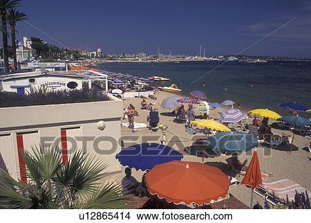 Picture -  France, Golfe-Juan, beach, Cote d' Azur, Provence, Alpes-Maritimes, Europe, Colorful beach umbrellas along the shore in Golfe-Juan on the Mediterranean Sea.. Fotosearch