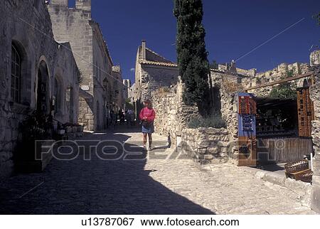 France, Les Baux de Provence, Bouche-du-Rhone, Provence, Europe, Woman tourist shopping along a narrow cobbled street in the medieval village of Les Baux de Provence. View Large Photo Image Stock Photo - France, Les Baux de Provence, Bouche-du-Rhone, Provence, Europe, Woman tourist shopping along a narrow cobbled street in the medieval village of Les Baux de Provence.. Fotosearch