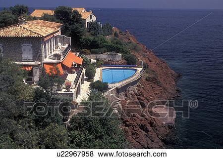 France, Massif de l' Esterel, Cote d' Azur, Provence, Var, Europe, House and swimming pool along the red rocky coast of Corniche de l' Esterel, coastal road, on the Mediterranean Sea. View Large Photo Image Stock Photo - France, Massif de l' Esterel, Cote d' Azur, Provence, Var, Europe, House and swimming pool along the red rocky coast of Corniche de l' Esterel, coastal road, on the Mediterranean Sea.. Fotosearch
