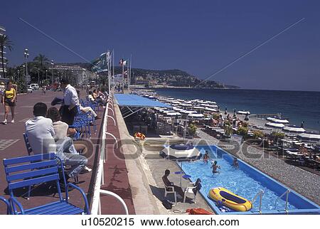 France, Nice, Cote d' Azur, Provence, Alpes-Maritimes, Europe, People sitting along the Promenade des Anglais watching people enjoying a day on the beach on the Mediterranean Sea in the city of Nice. View Large Photo Image Stock Photography - France, Nice, Cote d' Azur, Provence, Alpes-Maritimes, Europe, People sitting along the Promenade des Anglais watching people enjoying a day on the beach on the Mediterranean Sea in the city of Nice.. Fotosearch