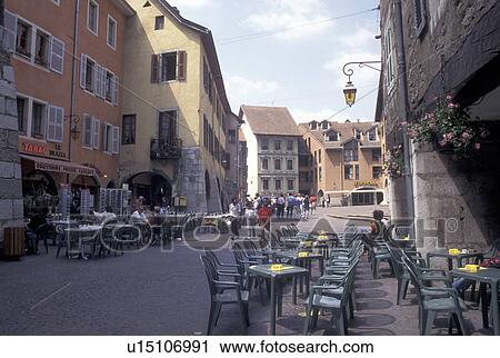 Stock Image -  France, outdoor cafT, Annecy, Haute-Savoie, Rhone-Alpes, Europe, Shops and outdoor cafes along a narrow pedestrian street in the old town of Annecy. . Fotosearch
