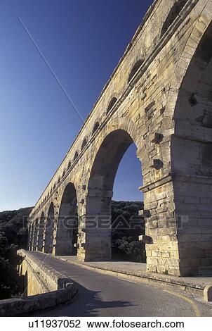 Stock Image -  France, Pont du Gard, aqueduct, Languedoc-Roussillon, Europe, Three-tiered 19 BC Roman Aqueduct, Pont du Gard spans the Gardon River.. Fotosearch