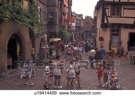Stock Photo -  France, Riquewihr, Alsace, Haut-Rhin, Europe, outdoor cafT, wine region, Half-timbered buildings in the picturesque village of Riquewihr in the wine region of Alsace.. Fotosearch