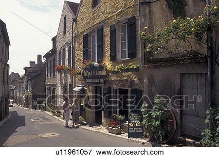 Stock Photo -  France, Vezelay, Burgundy, Yonne, wine region, Bourgogne, Europe, Shops along a narrow street in Vezelay in the wine region of Burgundy.. Fotosearch