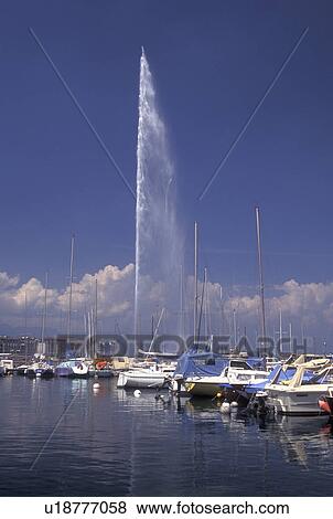 Geneva, Switzerland, Lake Geneva, Jet d' Eau sprays water high above the boats docked at a marina in the harbor of Lac Leman in Geneva. View Large Photo Image Stock Photo - Geneva, Switzerland, Lake Geneva, Jet d' Eau sprays water high above the boats docked at a marina in the harbor of Lac Leman in Geneva. . Fotosearch