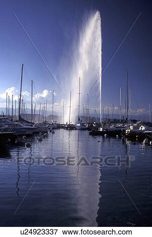 Geneva, Switzerland, Lake Geneva, Jet d' Eau sprays water high above the boats docked at a marina in the harbor of Lac Leman in Geneva. View Large Photo Image Stock Photo - Geneva, Switzerland, Lake Geneva, Jet d' Eau sprays water high above the boats docked at a marina in the harbor of Lac Leman in Geneva. . Fotosearch