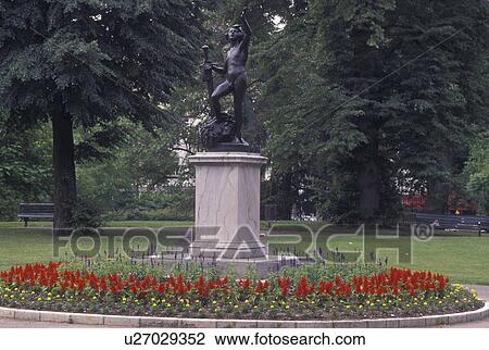 Stock Image -  Geneva, Switzerland, Statue surrounded by beautiful flowers at Jardin Anglais in Geneva . Fotosearch