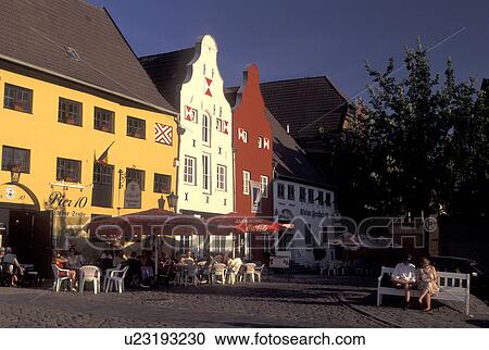 Stock Image -  Germany, Wismar, Europe, Mecklenburg-Pomerania, Outdoor cafTs and gabled buildings at Markt in downtown Wismar. Fotosearch