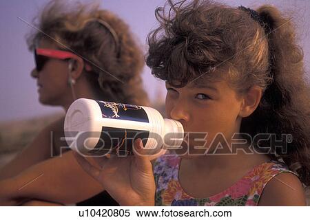 girl, Atlanta, GA, Georgia, 8 year old girl drinking from a water bottle winking at the camera sitting next to her mother on Stone Mountain in Atlanta. View Large Photo Image Stock Photography - girl, Atlanta, GA, Georgia, 8 year old girl drinking from a water bottle winking at the camera sitting next to her mother on Stone Mountain in Atlanta.. Fotosearch