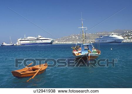 Greece, Mykonos, Greek Islands, Cyclades, Greece, Europe, Colorful old fishing boat and huge ferries docked in Mykonos Harbor on the Aegean Sea. View Large Photo Image Stock Photo - Greece, Mykonos, Greek Islands, Cyclades, Greece, Europe, Colorful old fishing boat and huge ferries docked in Mykonos Harbor on the Aegean Sea.. Fotosearch