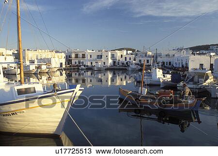 Stock Image -  Greece, Paros, Greek Islands, Naoussa, Cyclades, Europe, Fisherman slowly cruises into Naoussa Harbor on Paros Island on the Aegean Sea.. Fotosearch