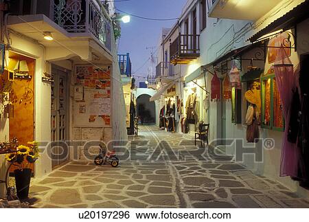 Stock Photograph -  Greece, Paros, Greek Islands, Parikia, Cyclades, Europe, Shops along the narrow pedestrian streets in Plateia Mavrogenous in the evening in the town of Parikia on Paros Island.. Fotosearch