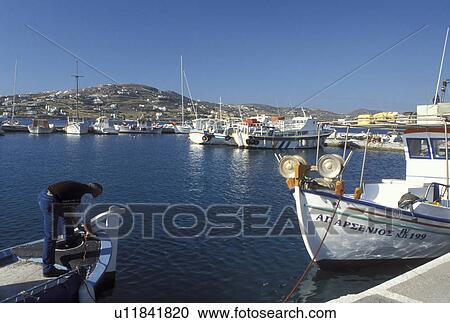 Stock Image -  Greece, Paros, Parikia, Greek Islands, Cyclades, Europe, Fisherman on fishing boat docked in the harbor of Parikia on Paros Island on the Aegean Sea.. Fotosearch