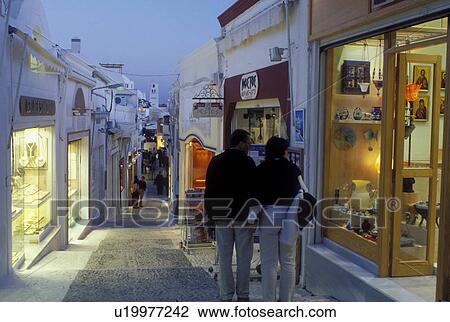 Stock Image -  Greece, Santorini, Greek Islands, Fira, Cyclades, Europe, Shops and boutiques along a narrow pedestrian street in the village of Fira in the evening on Santorini Island on the Aegean Sea. . Fotosearch
