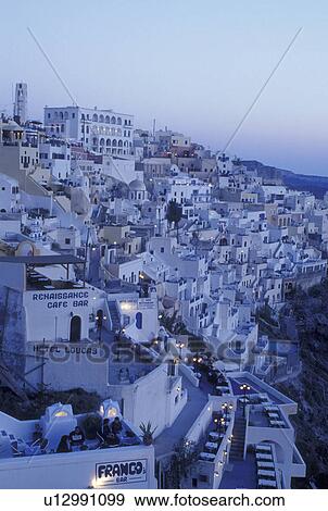 Greece, Santorini, Greek Islands, Fira, Cyclades, Europe, Outdoor restaurants and cafTs in the village of Fira in the evening on the steep hillside of Santorini Island on the Aegean Sea. View Large Photo Image Stock Photo - Greece, Santorini, Greek Islands, Fira, Cyclades, Europe, Outdoor restaurants and cafTs in the village of Fira in the evening on the steep hillside of Santorini Island on the Aegean Sea.. Fotosearch