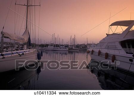 Picture -  harbor, France, Antibes, Cote d' Azur, Provence, Alpes-Maritimes, Europe, Yachts docked in Port Vauban Harbor on the Mediterranean Sea in the city of Antibes at sunset. . Fotosearch