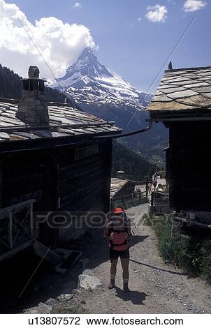 Stock Image -  hiking, Switzerland, Matterhorn, Findeln, Valais, Alps, Woman hiking on trail through the mountain village of Findeln above Zermatt with a view of the Matterhorn in the Swiss Alps.. Fotosearch