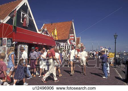 Stock Photograph -  Holland, Volendam, Netherlands, Noord-Holland, Europe, People walking on the waterfront of the harbor on Markermeer in the town of Volendam.. Fotosearch