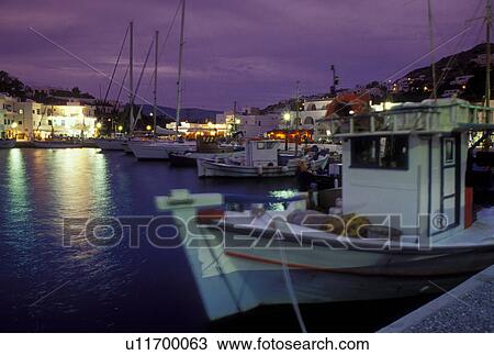 Stock Image -  Ios, Greek Islands, Cyclades, Ormos, Greece, Europe, Fishing boats docked in the harbor of Ormos on Ios Island in the evening on the Aegean Sea.. Fotosearch