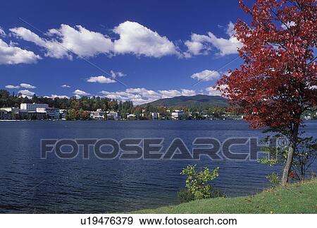 Stock Photo -  Lake Placid, NY, New York, The Adirondacks, Scenic view of the resort town of Lake Placid and Mirror Lake in the autumn.. Fotosearch
