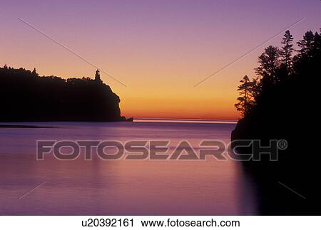 Stock Image -  lighthouse, sunrise, Lake Superior, North Shore Drive, Two Harbors, MN, Minnesota, Split Rock Lighthouse situated on a high cliff on the north shore of Lake Superior at Split Rock Lighthouse State Park in Two Harbors at sunrise.. Fotosearch